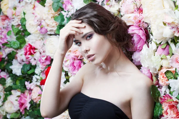 Portrait of beautiful fashion girl, sweet, sensual. Beautiful makeup and messy romantic hairstyle. Flowers background.