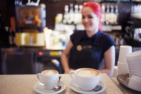 Happy girl Barista gives coffee  to the customers