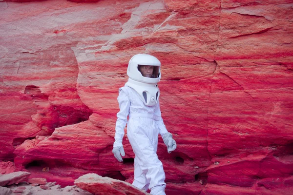 Futuristic astronaut on crazy pink planet, image with the effect of toning