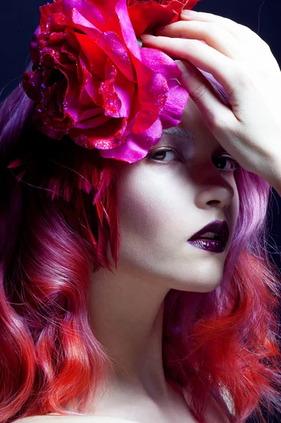 Beautiful girl with pink hair, large rose flower in her hair