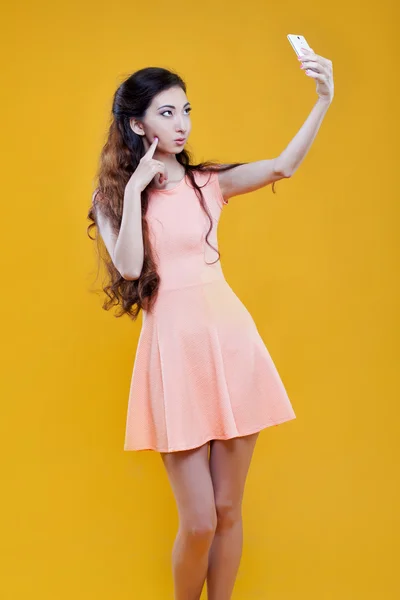 Fashion asian young  girl   taking picture of herself, selfie. Portrait on yellow background