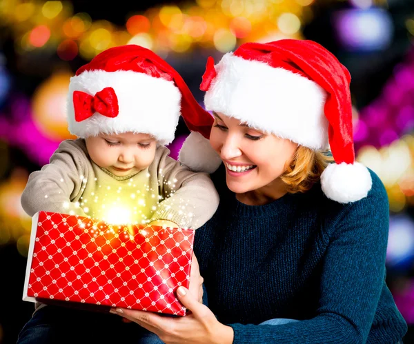 Mother with little child opens the gift