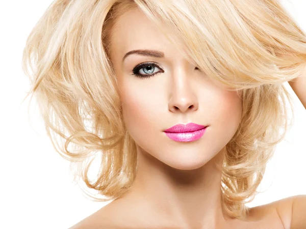 Woman with blond hair and bright makeup