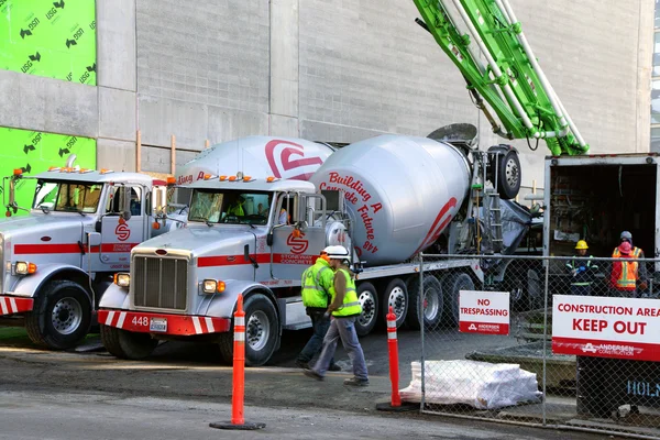 Cement trucks unloading at construction site