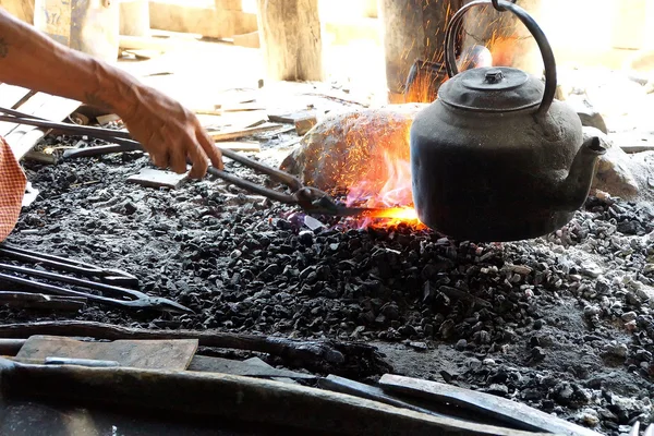 Heating iron in a charcoal fire