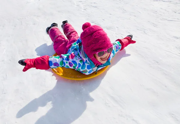 Girl riding on snow slides