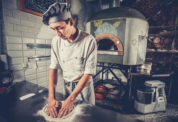 Young chef preparing dough