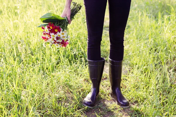 Girl in rain boots with flowers