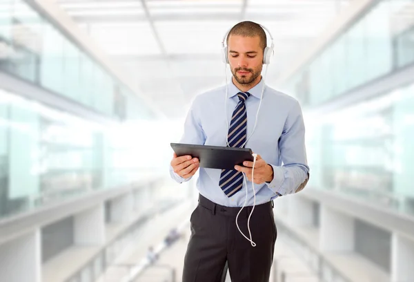 Businessman with tablet pc and headphones, at the office