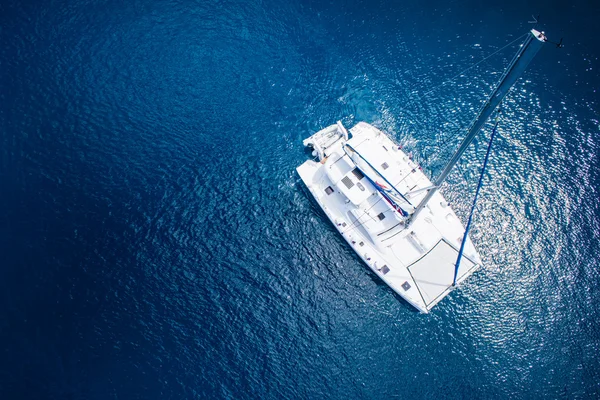 Amazing view to Catamaran sailing in open sea at windy day. Drone view - birds eye