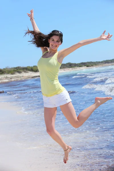 Smiling Pretty Woman in Jump Shot at Beach