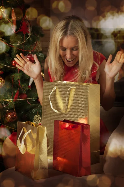 Young woman opening Christmas presents