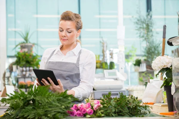 Florist Using Digital Tablet In Flower Shop