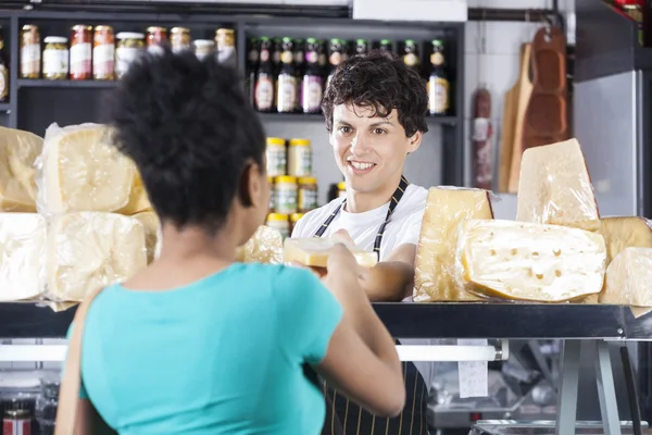 Happy Salesman Selling Cheese To Female Customer