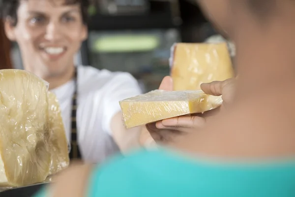 Happy Salesman Selling Cheese To Female Customer