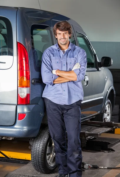 Confident Mechanic Standing Arms Crossed By Car