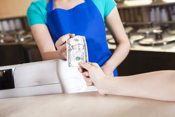 Girls Hand Paying Money To Worker In Ice Cream Parlor