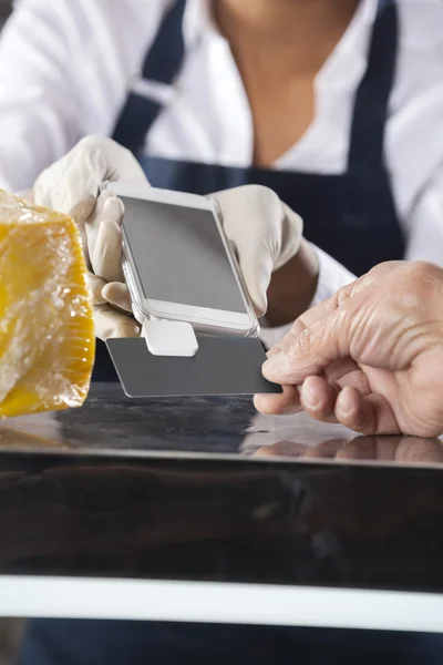 Saleswoman Accepting Payment From Customer In Cheese Shop