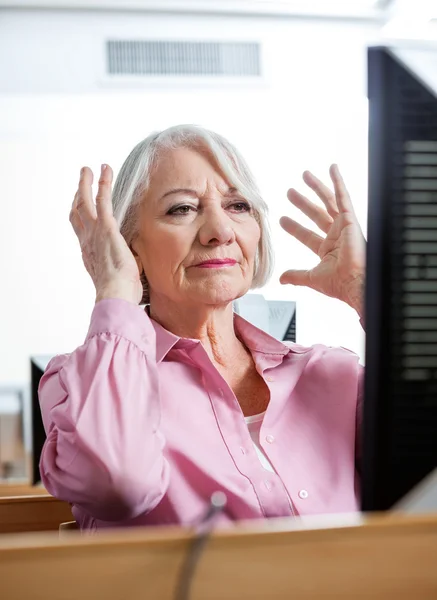 Stressed Senior Woman Looking At Computer In Classroom
