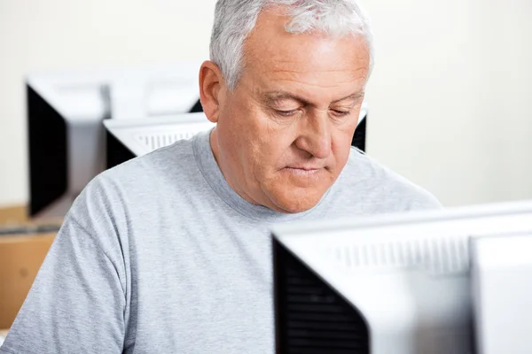 Senior Man Using Computer In Classroom