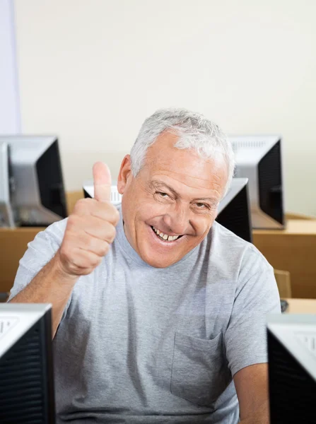 Smiling Senior Man Gesturing Thumbs Up In Computer Class