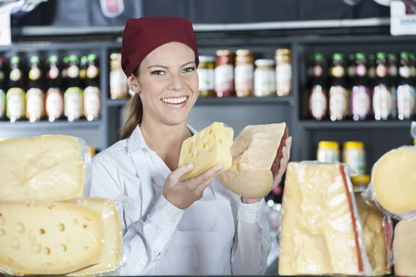 Happy Saleswoman Holding Fresh Cheese In Store