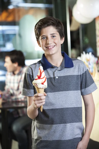 Smiling Boy Showing Vanilla Ice Cream At Parlor
