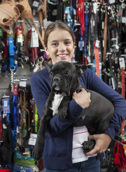 Smiling Girl Carrying French Bulldog In Store
