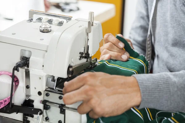 Fashion Designer Sewing Fabric At Workbench