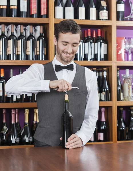 Smiling Bartender Opening Wine Bottle