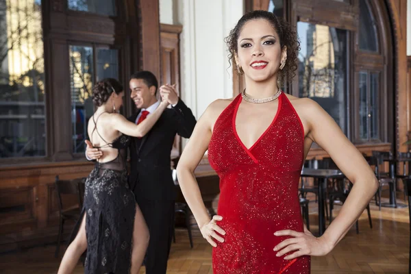 Woman With Hands On Hip Standing While Dancers Doing Tango