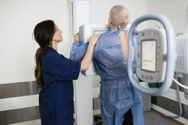 Mature Radiologist Taking Xray Of Man In Hospital