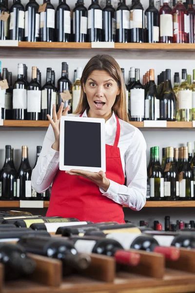 Surprised Saleswoman Showing Blank Digital Tablet In Wine Shop