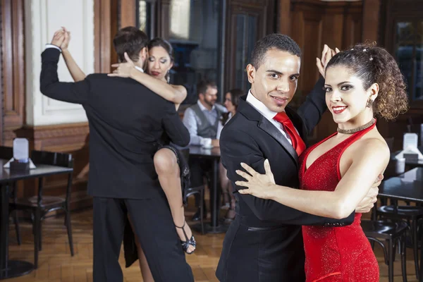 Confident Man And Woman Performing Tango In Restaurant