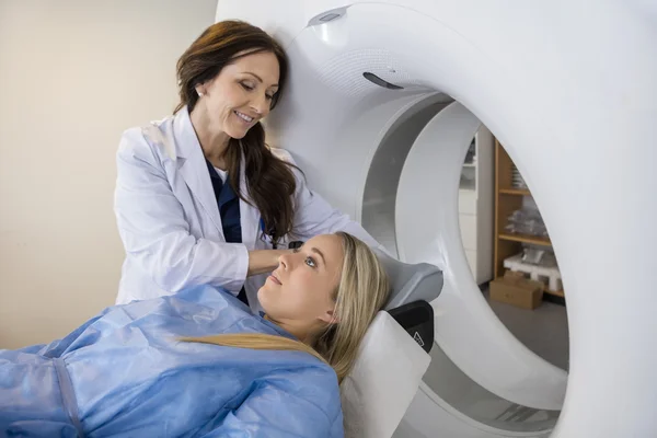 Doctor Preparing Patient For MRI Scan In Hospital