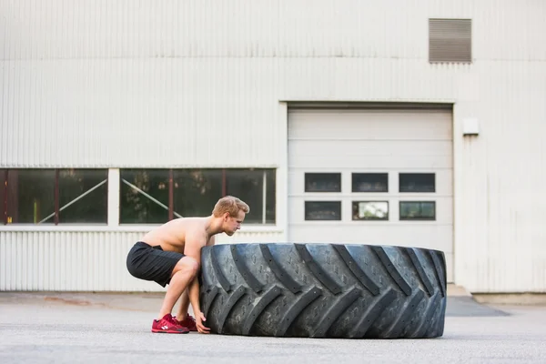 Determined Athlete Lifting Large Tire