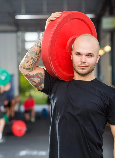 Man Carrying Weightlifting Plate