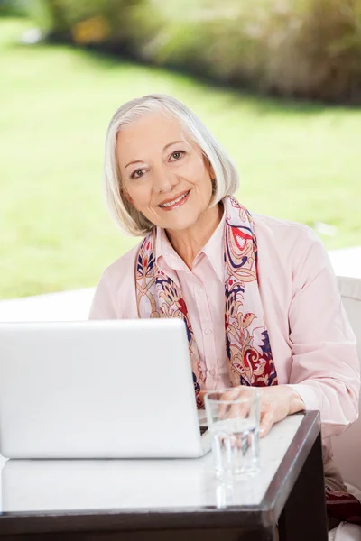 Senior Woman With Laptop At Nursing Home Porch