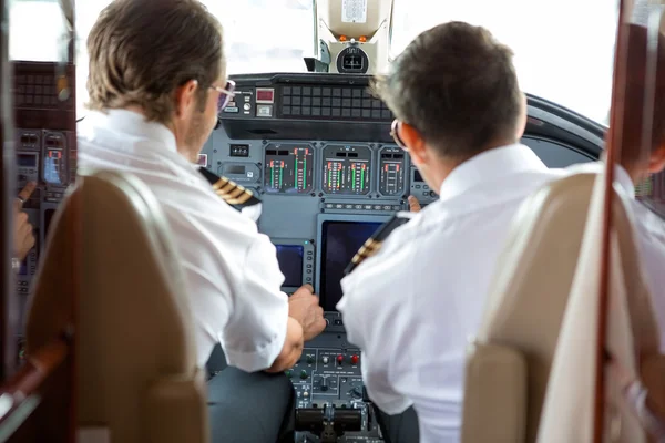 Pilots Operating Controls Of Corporate Jet