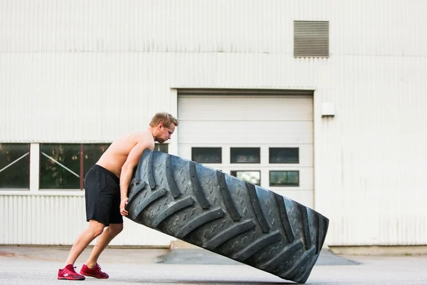 Male Athlete Flipping Large Tire