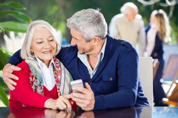 Affectionate Grandson And Grandmother Using Smartphone