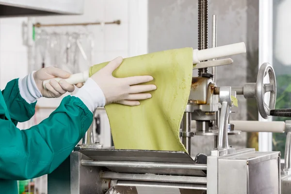 Chef Wrapping Pasta Sheet On Rolling Pin Into Machine