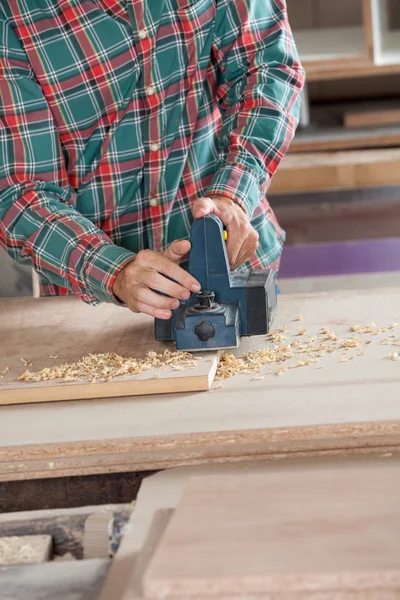 Worker Using Electric Planer On Wood
