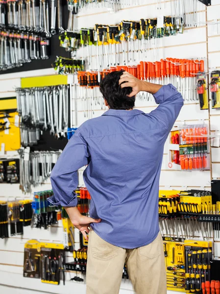 Confused Customer Scratching Head In Hardware Shop