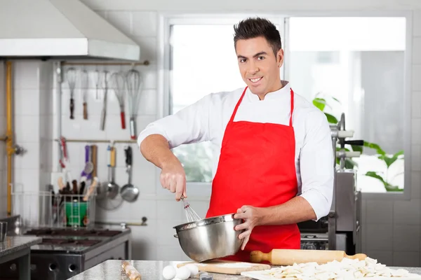 Confident Chef Using Eggbeater To Prepare Ravioli Pasta
