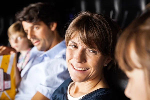 Happy Woman Talking To Daughter While Watching Movie In Theater