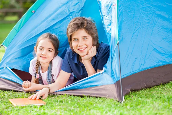 Happy Siblings Lying In Tent