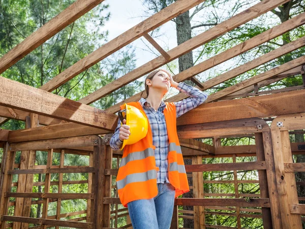 Tired Construction Worker Standing In Timber Cabin At Site