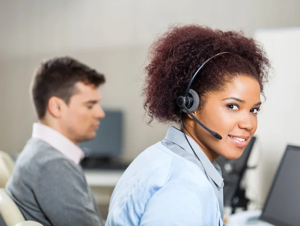 Customer Service Representative Wearing Headset At Office Desk