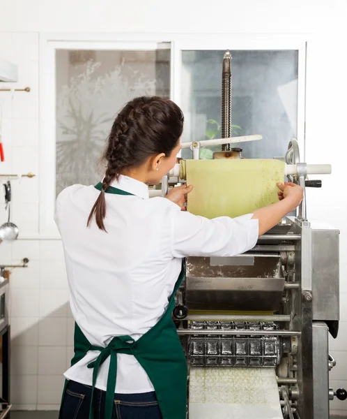 Female Chef Processing Pasta Sheet In Machine